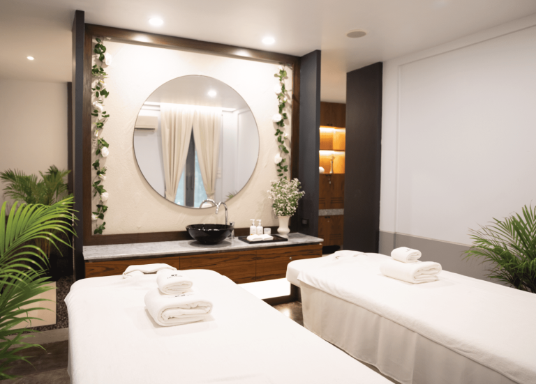 Treatment Room With 2 Massage Tables And Circular Mirror